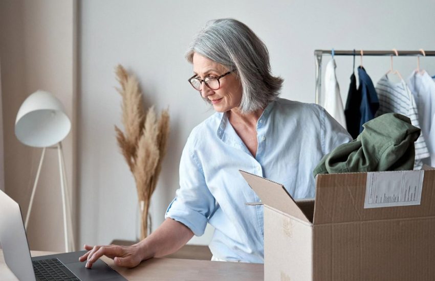 Small business owner in Dubai preparing rental items and managing online listings on a laptop